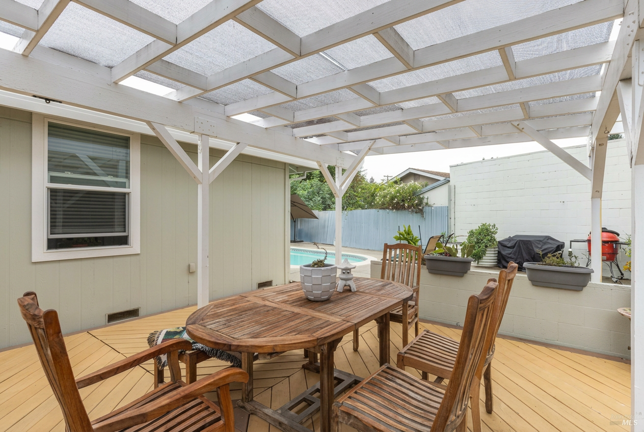 Covered patio with dining table under white pergola